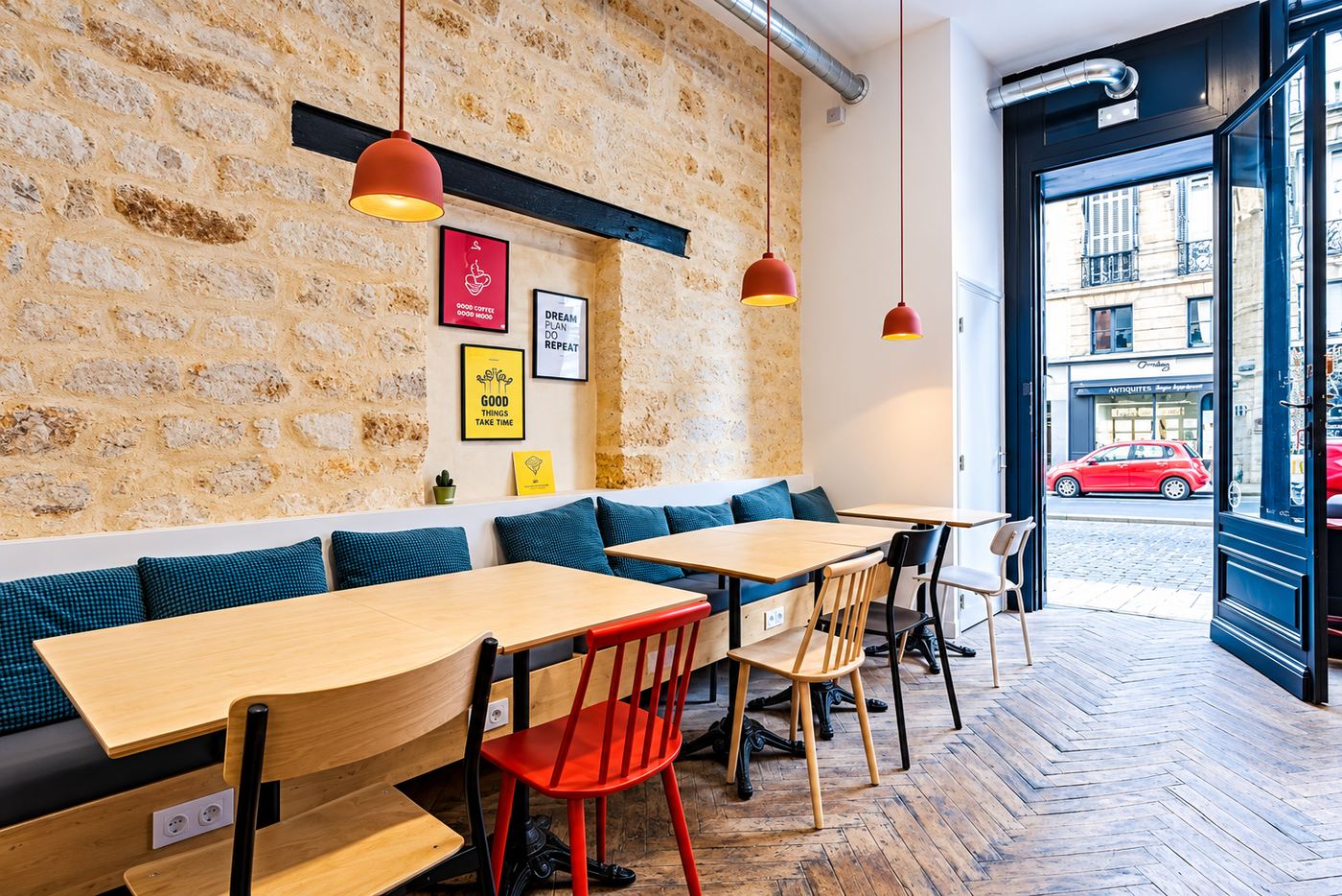 Café coworking Anticafé à Bordeaux : salle avec mur en pierre, banquette et tables pour travailler, rue Duffour-Dubergier